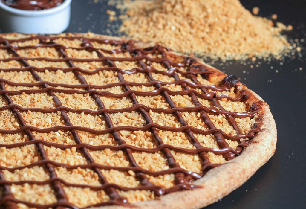 Creme de paçoca cremosa, farofa crocante de amendoim e chocolate ao leite. Pizza de Paçoca