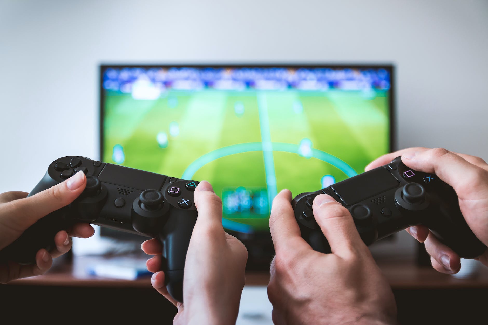pexels-photo-442576 two people holding black gaming consoles