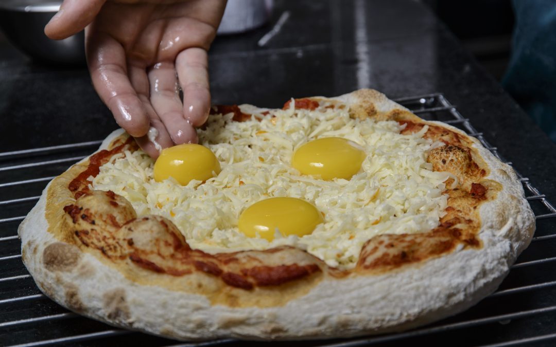 Releitura da pizza portuguesa com gema mole faz sucesso em Curitiba